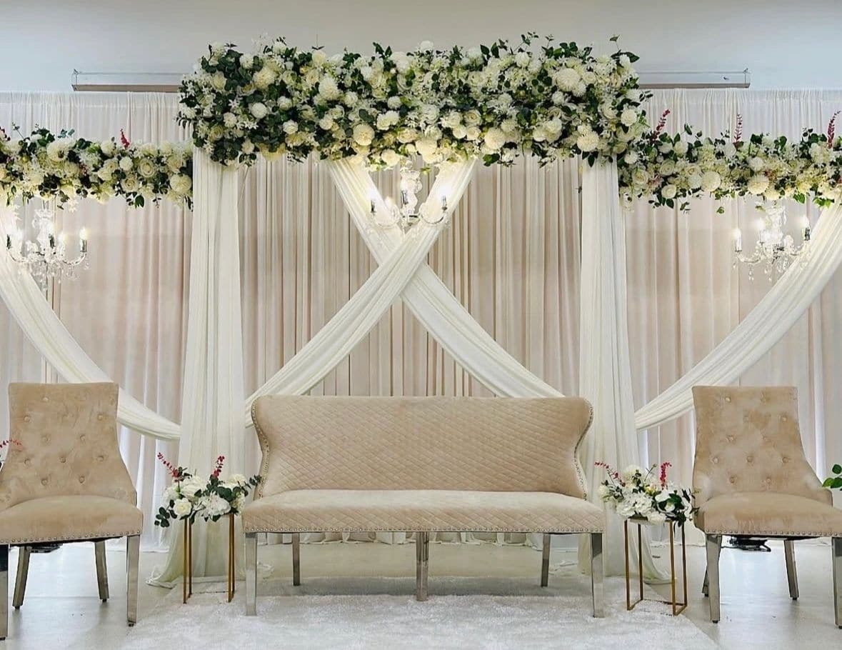 Ivory ceremonial seating framed with soft draping and florals