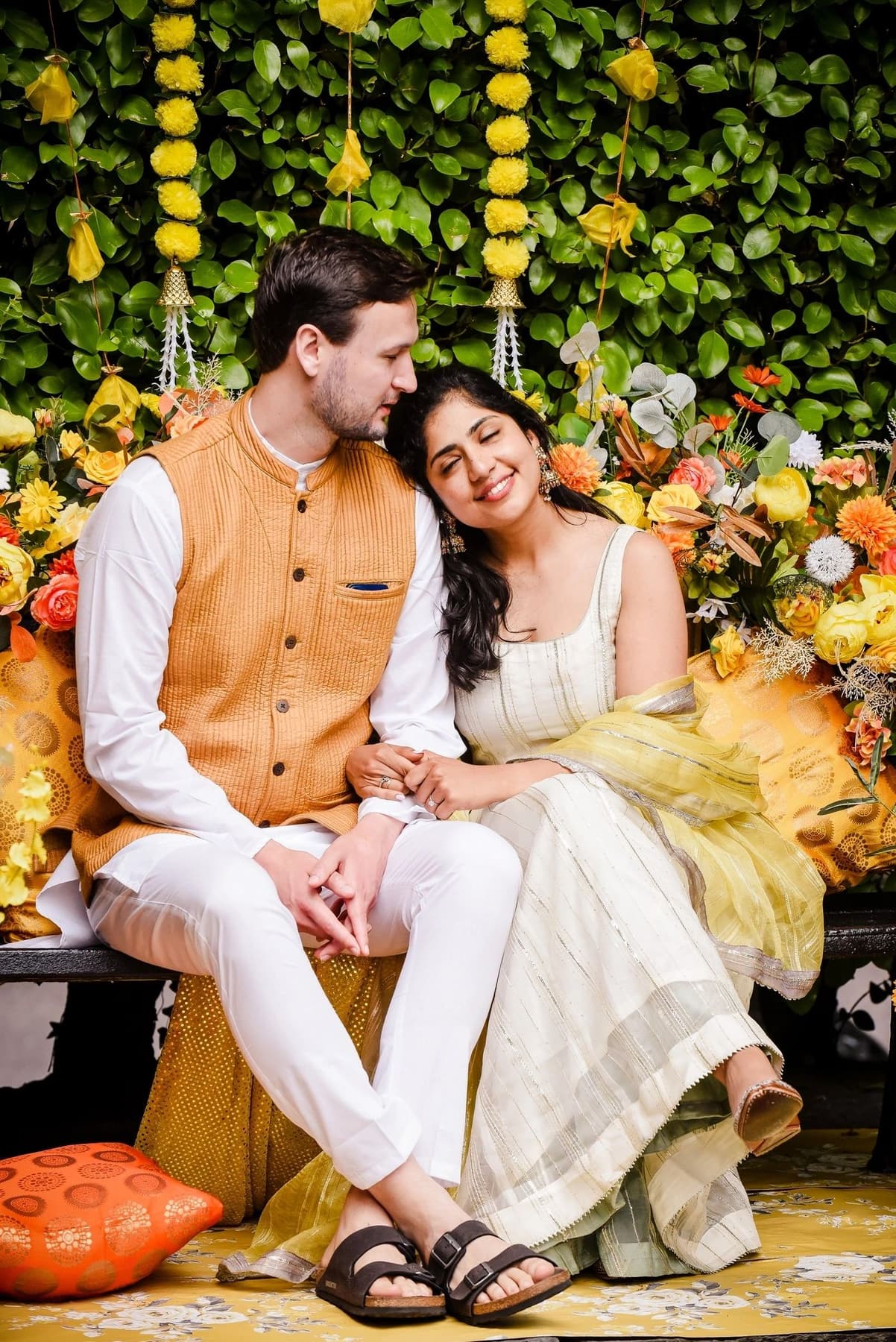 A couple seated together during a colourful multicultural celebration