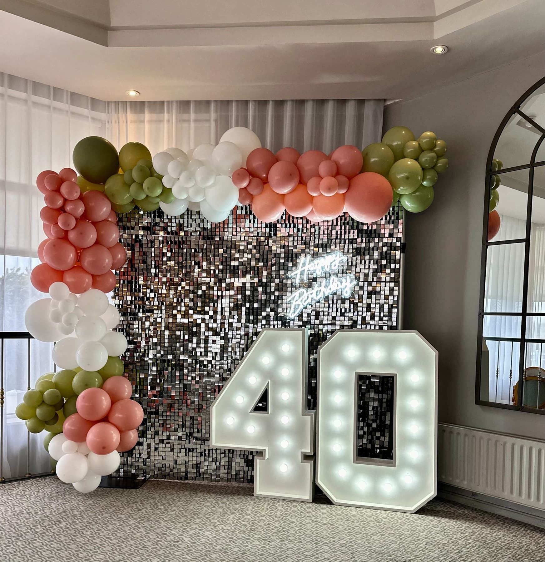 Colourful celebration backdrop with floral and balloon styling