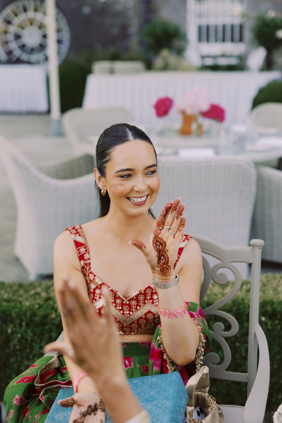 A wedding guest showing detailed mehndi during a pre-wedding celebration