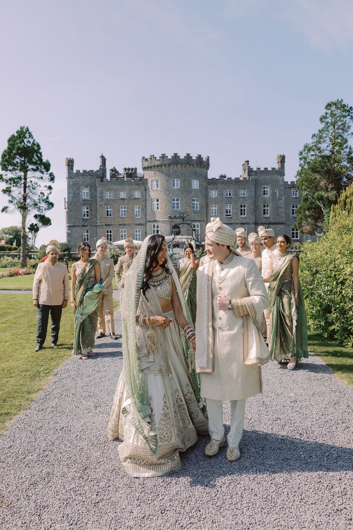 A couple in Indian wedding attire outside an Irish castle venue