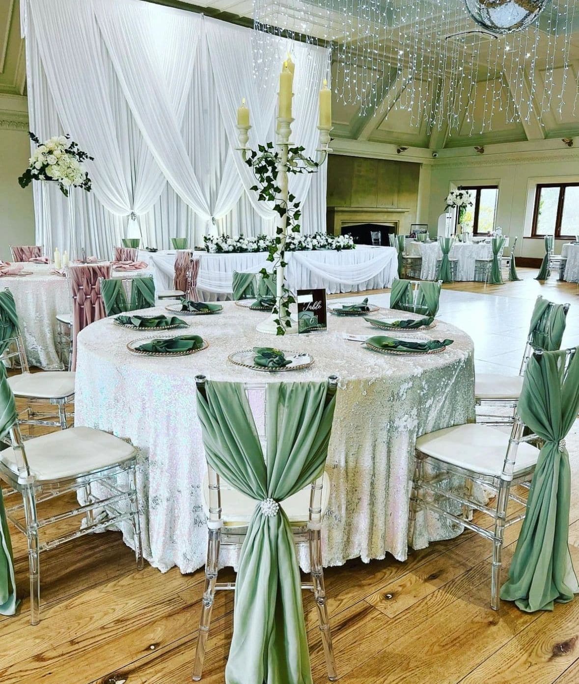 Reception room styled with green chair drapes and coordinated table decor