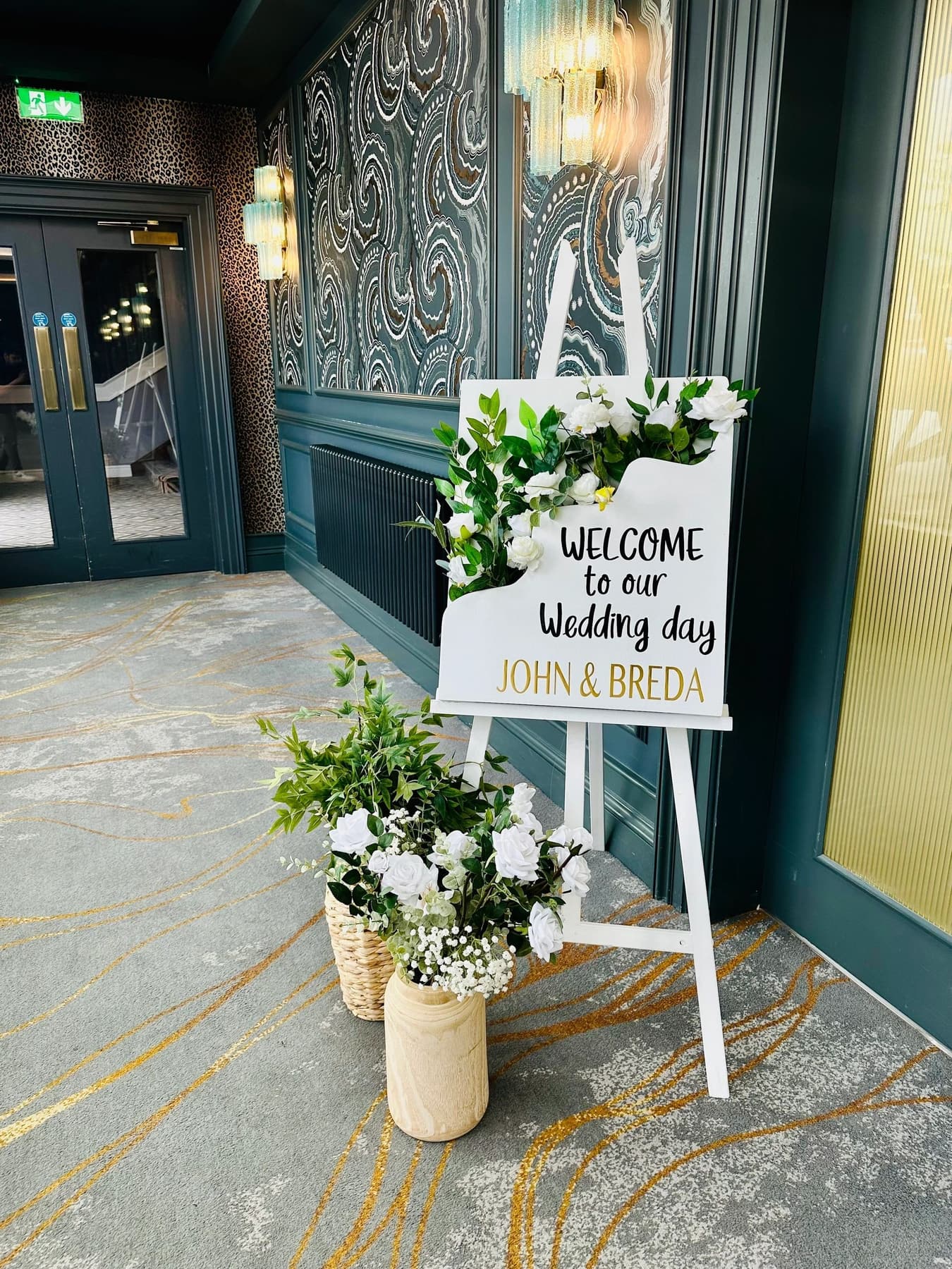 Wedding welcome sign styled with white florals and lanterns